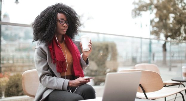 Lady using a laptop and drinking coffee