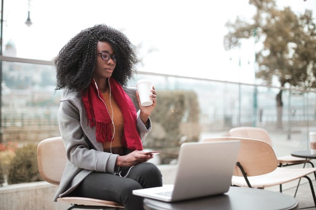 Lady using a laptop and drinking coffee